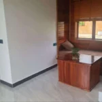 Built-in wooden seating area with storage cabinet and window views of garden